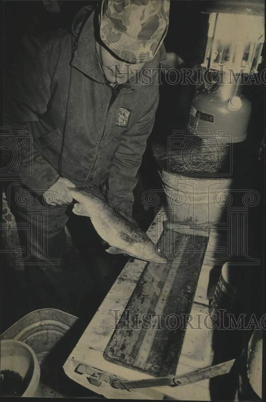 1986 Press Photo Ronald Theis, Department Resources measures speared fish - Historic Images