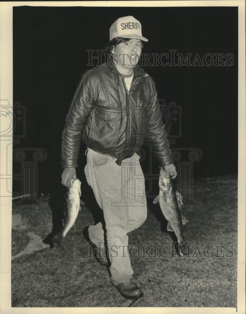 1986 Press Photo Chippewa Indian Lloyd Fowler carries fish from Balsam Lake - Historic Images