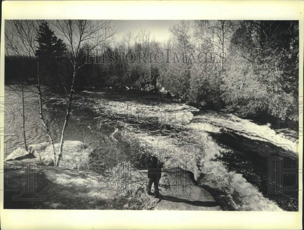 1984 Press Photo Man walks along river on Menominee Indian Reservation - Historic Images