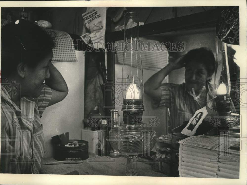 1973 Press Photo Mrs. Fleming Chippewa, fixes her hair by oil lamp light.-Historic Images