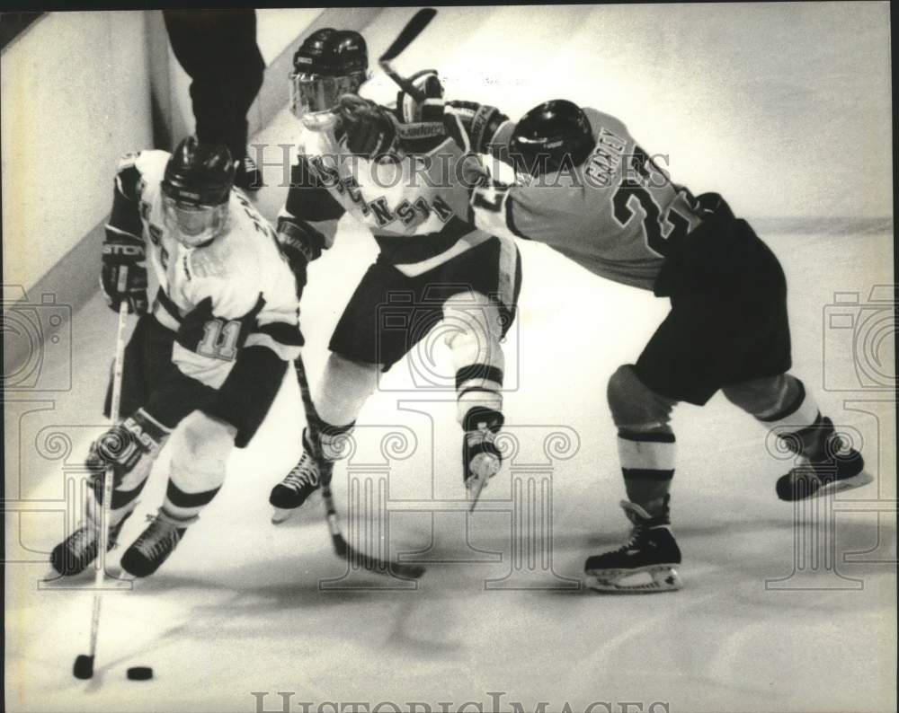 1990 Press Photo Wisconsin hockey players battle Michigan Tech's Liam Garvey - Historic Images