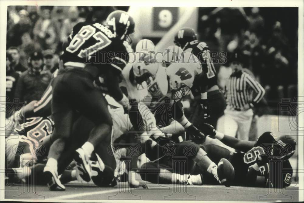 1992 Press Photo Wisconsin defense swarms a fumble during Northwestern game. - Historic Images