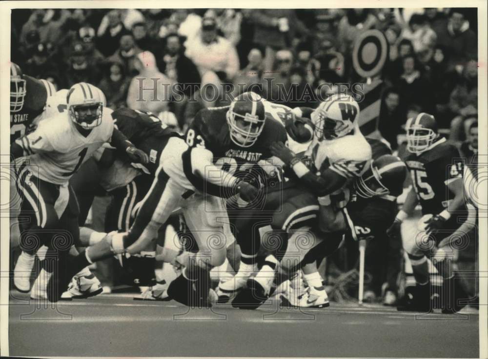 1992 Press Photo Wisconsin back Jason Burns gets tackled by Michigan defense - Historic Images