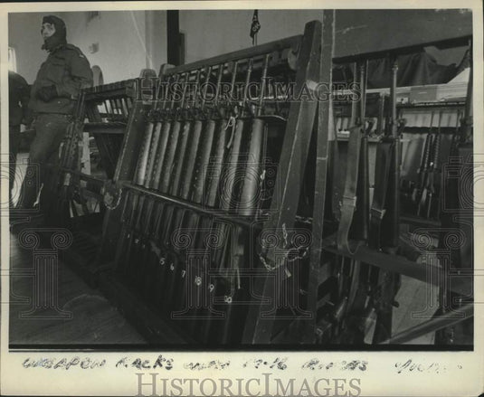 1975 Press Photo Man leans on rack of guns - mjc38555 - Historic Images