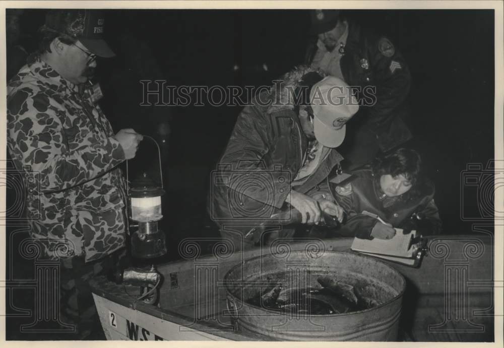 1990 Press Photo Chippewa Indians counting fish in bin that they caught. - Historic Images