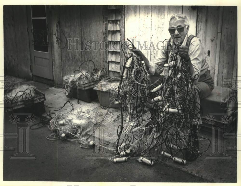 1990 Press Photo Red Cliff Chippewa angler Wilford Peterson &amp; damaged gill net - Historic Images