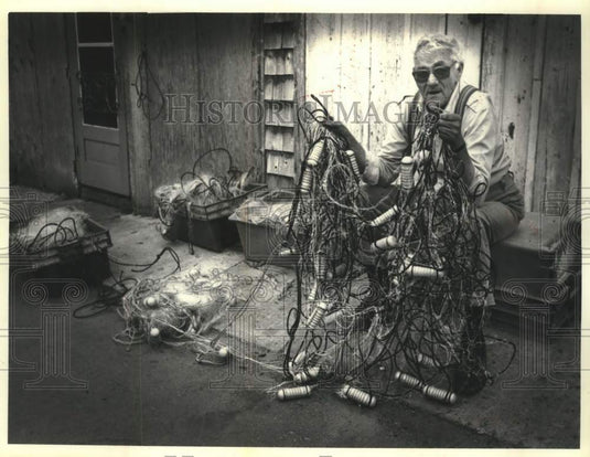1990 Press Photo Red Cliff Chippewa angler Wilford Peterson & damaged gill net - Historic Images