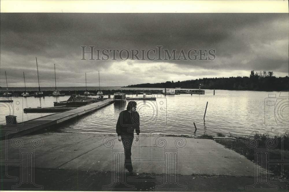 1982 Press Photo Henry Buffalo Jr. walks alone at Red Cliff reservation&#39;s harbor - Historic Images