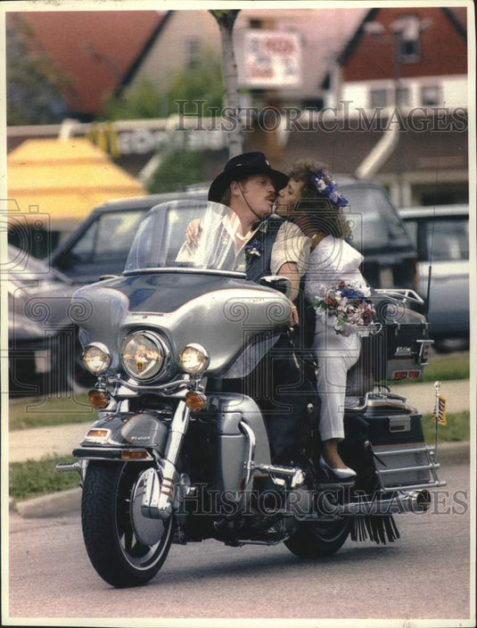 1993 Press Photo Newlyweds Howard Becker & d'Arcy Bosell kiss on Harley-Davidson - Historic Images