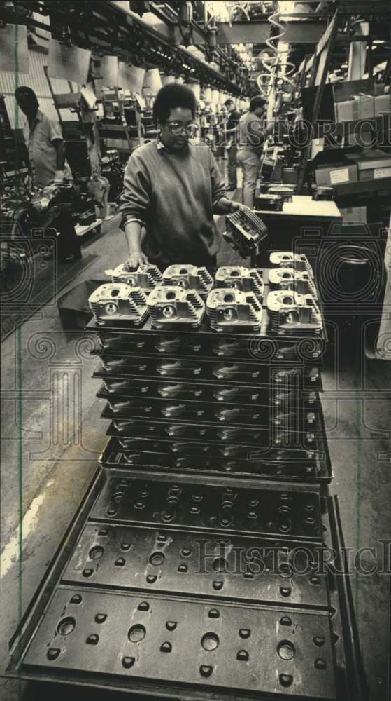 1987 Press Photo Worker handles cylinder heads for Harley-Davidson Motor Inc. - Historic Images