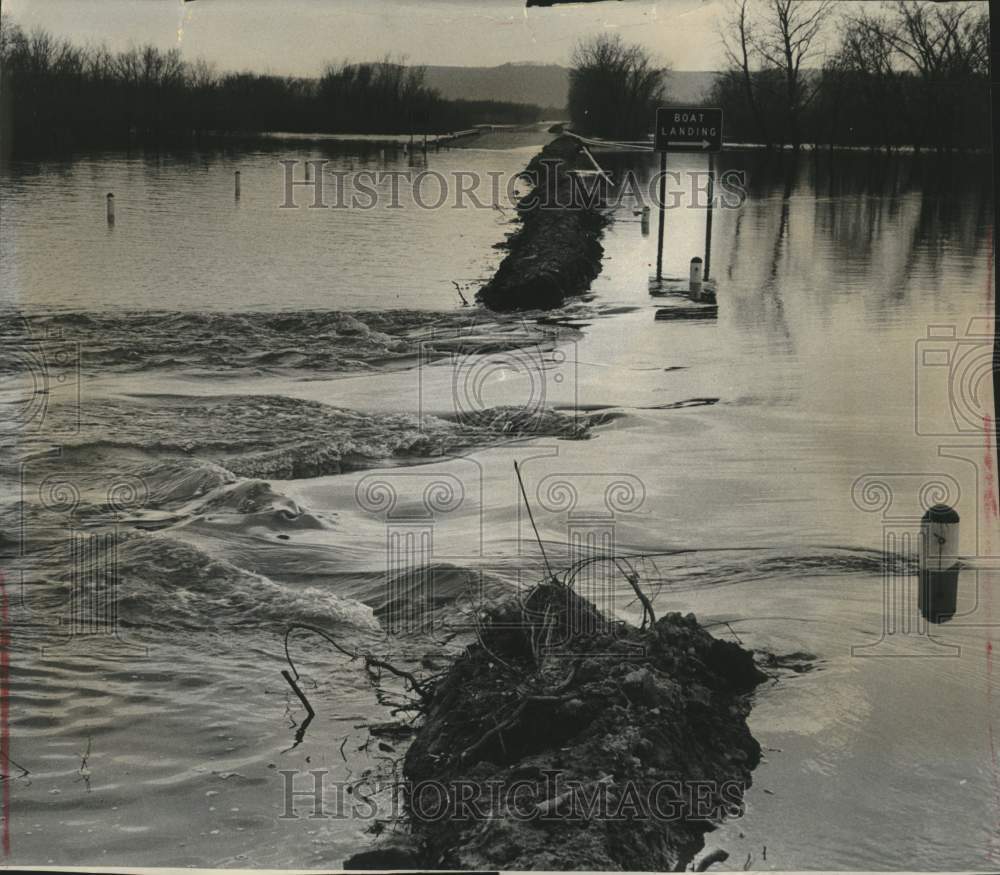 1965, floodwaters breaking over the earth dike along Wisconsin road - Historic Images