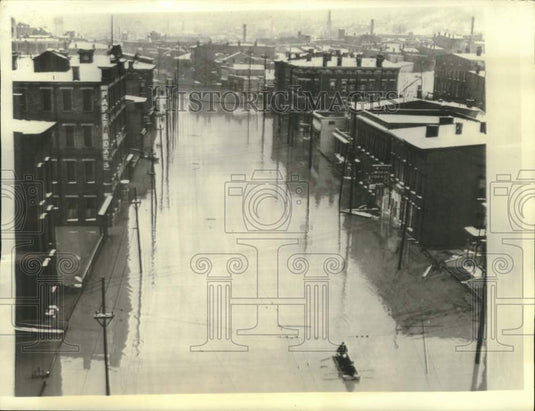 1937 man guides boat through flooded streets of Cincinnati, Ohio - Historic Images