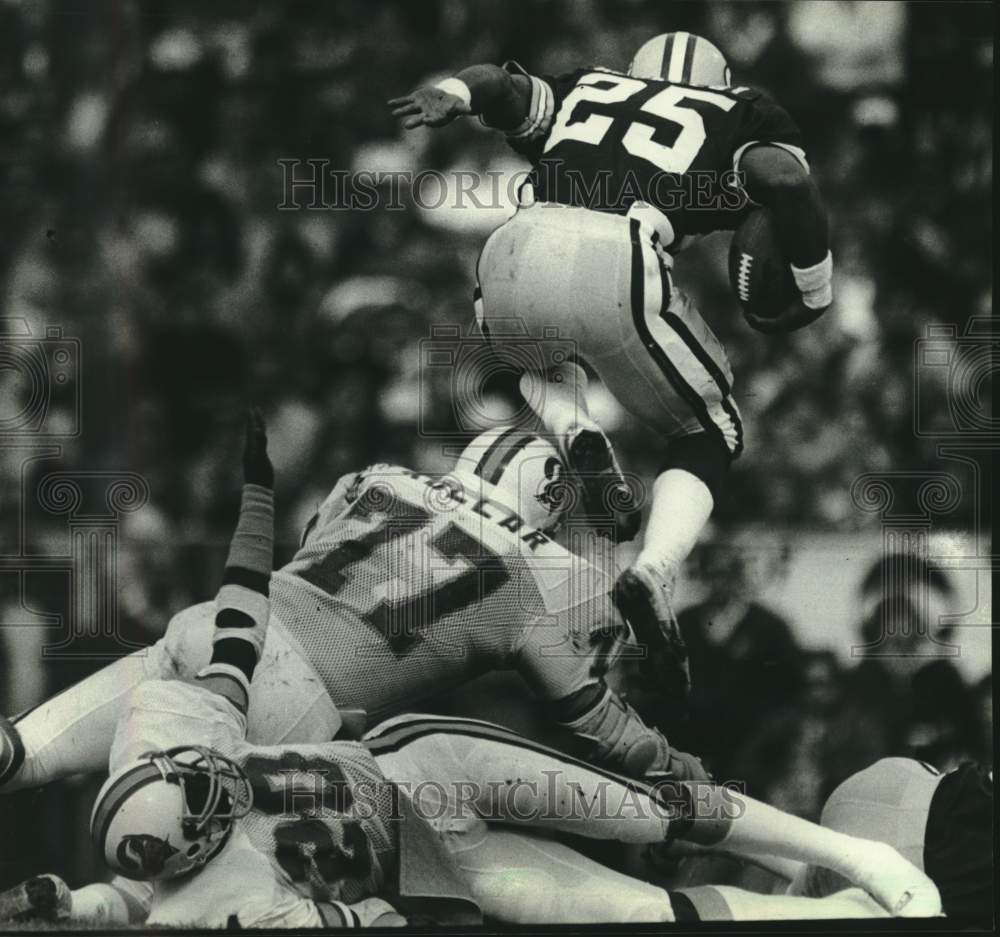 1981 Press Photo Green Bay Packers' Harlan Huckleby leaps over player, football - Historic Images