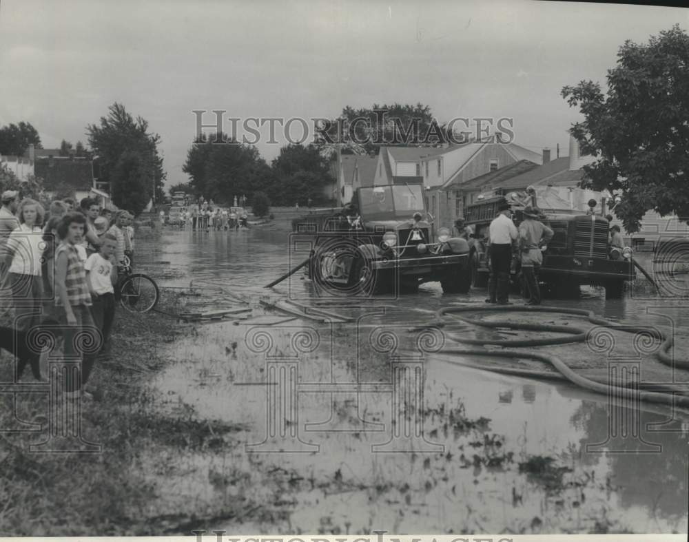 1952 Milwaukee fire department pumps flood waters out of street. - Historic Images