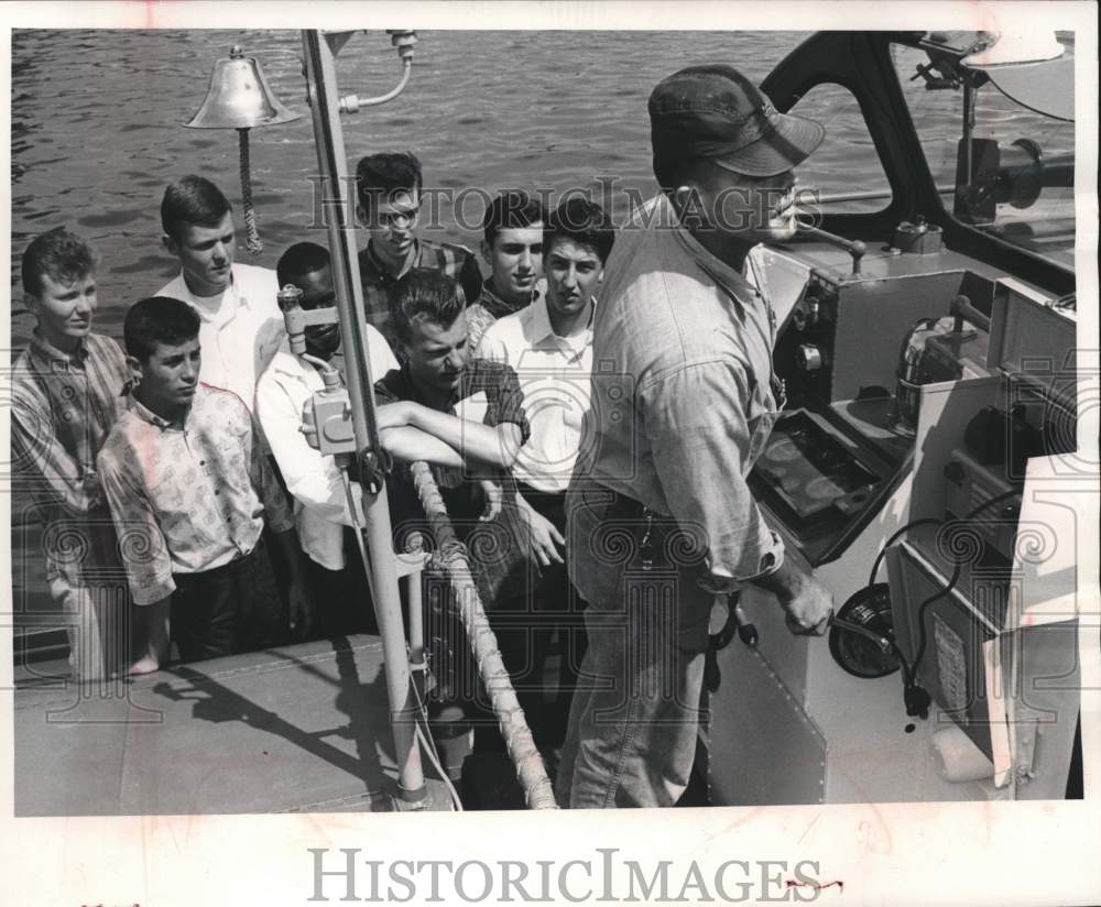 1965, high-schoolers watch coast guardsman A. Rust steer boat, WI - Historic Images