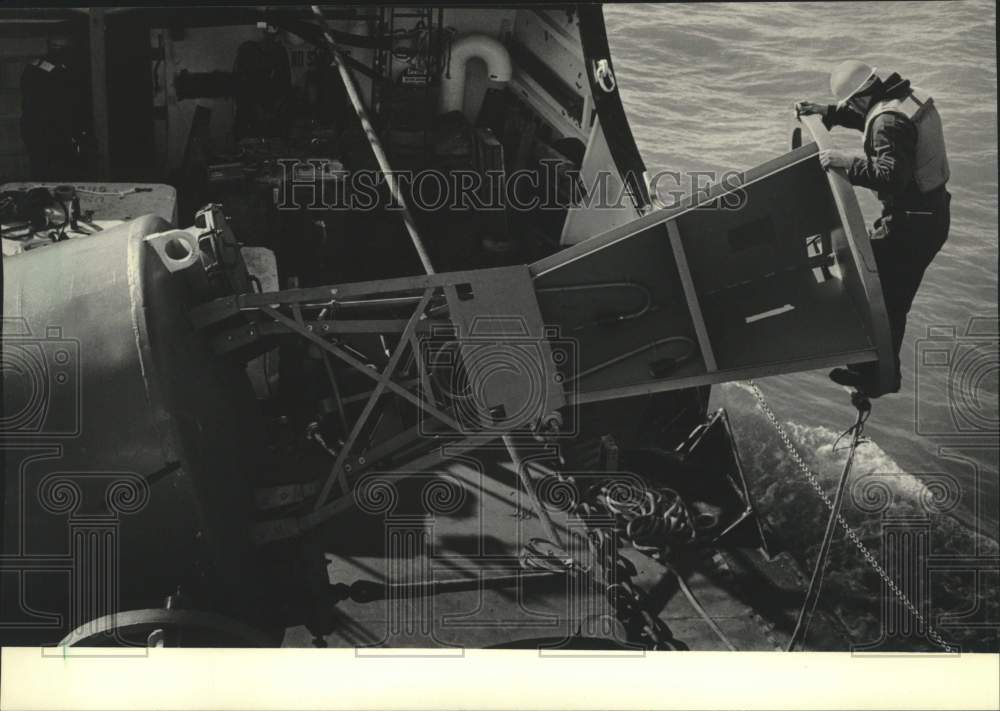 1985 Press Photo United States Coast Guard Crewman Performs Light Test On Buoy - Historic Images