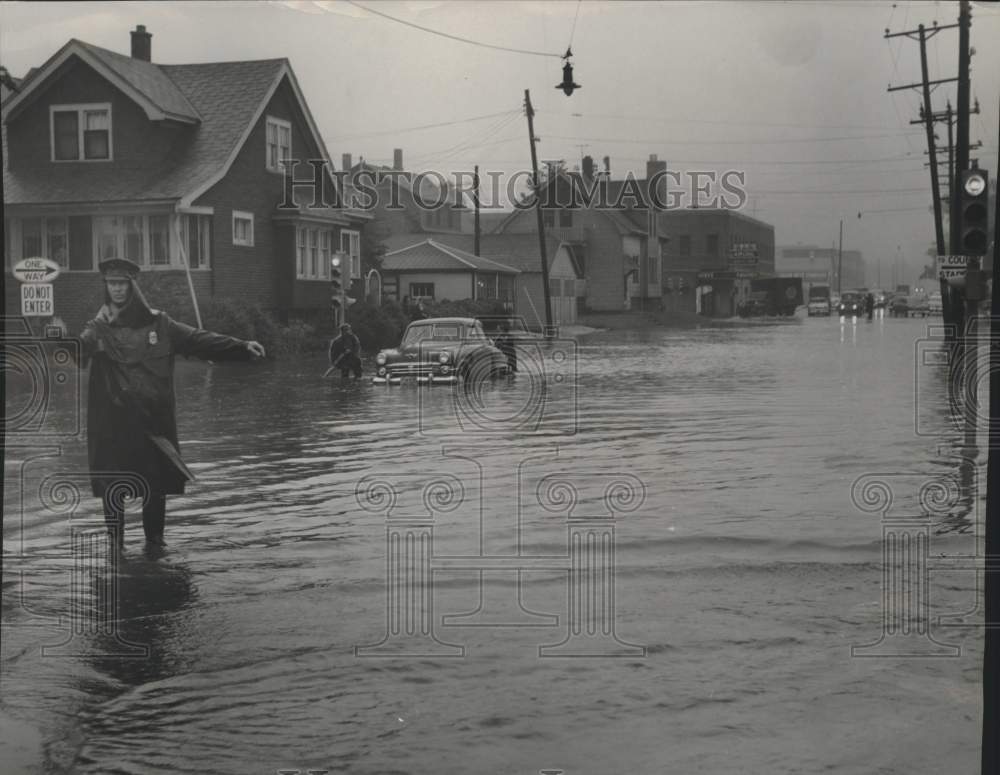 1954, Patrolman William Emanuelson diverts traffic during flood, WI - Historic Images