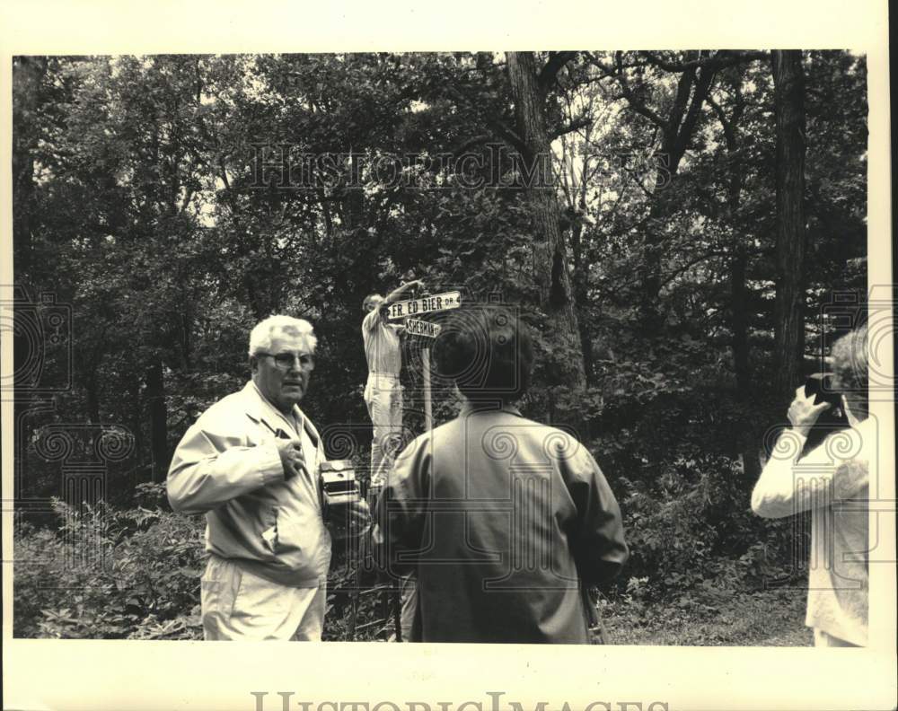 1987 Press Photo Ed McDonough, erects signs commemorating Father Ed Bier, WI - Historic Images