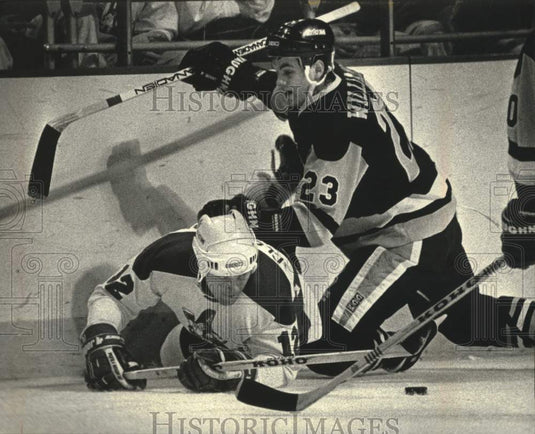 1991 Press Photo Milwaukee Admiral's Shaun Clouston gets run off the puck - Historic Images