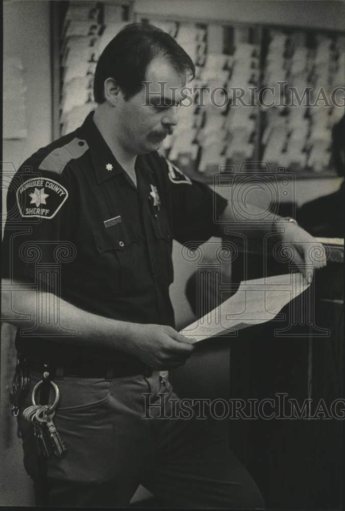 1985 Press Photo Deputy James Matykowski reads paperwork in Milwaukee - Historic Images