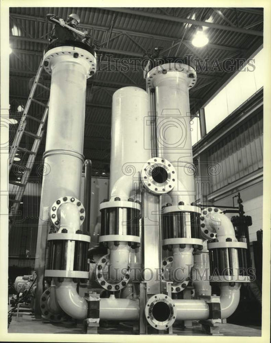 1985 Press Photo Zimpro employee uses pipe wrench to tighten bolts on huge pump. - Historic Images