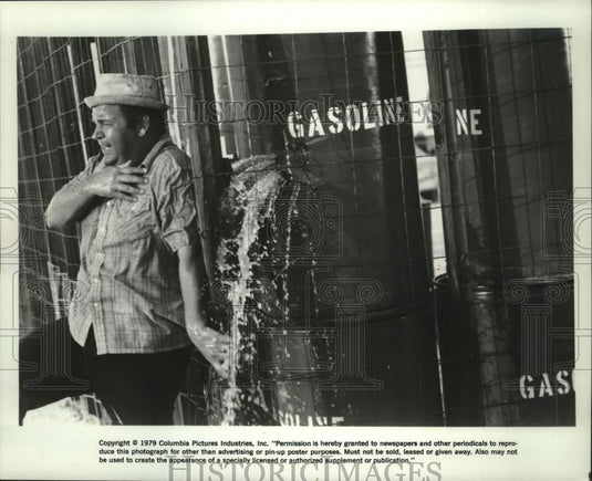 1979 Press Photo Dom DeLuise hides by barrels of gasoline in movie "Hot Stuff." - Historic Images
