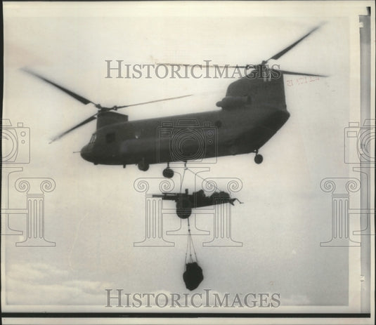 1966 Chinook helicopter carrying a 105 millimeter piece of artillery - Historic Images