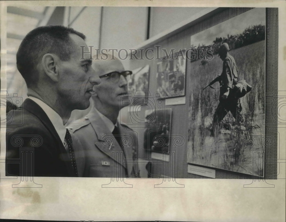 1965 Bob Blackwell views his photos on display in library, Wisconsin - Historic Images