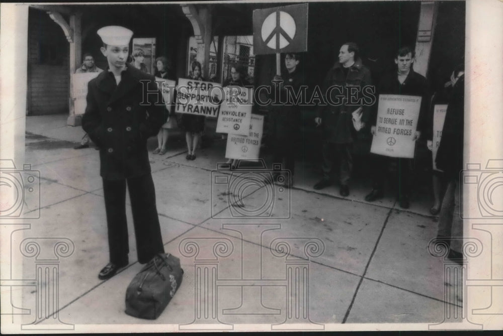 1966 Press Photo Demonstrators outside Boston army base as sailor waits for bus - Historic Images