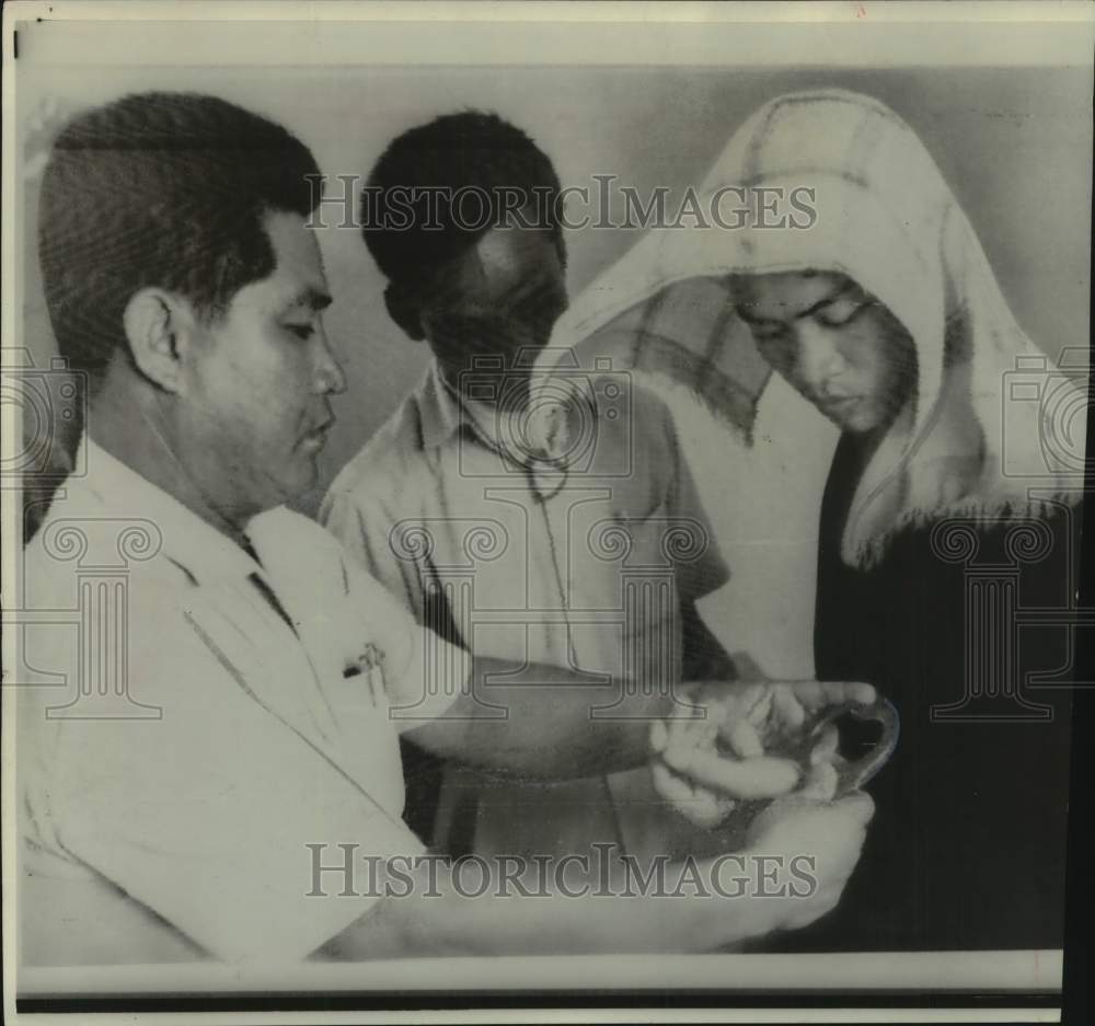 1966 Press Photo Saigon officer clapped handcuffs on Buddhist in a raid. - Historic Images