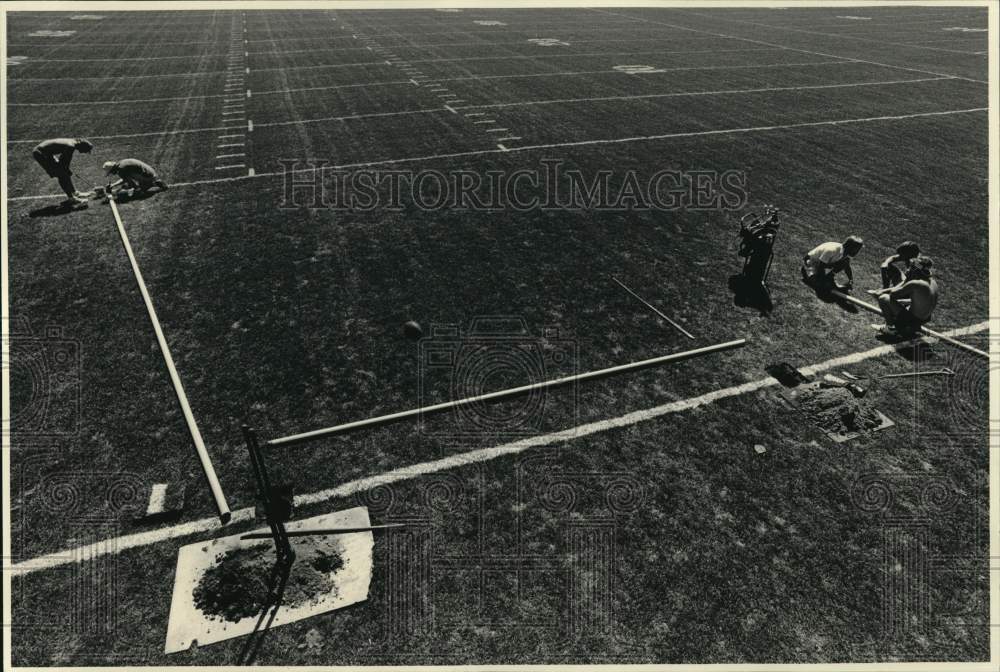 1987 Press Photo Pet Schoemann, Terry Natchigall paint goal posts at field- Historic Images