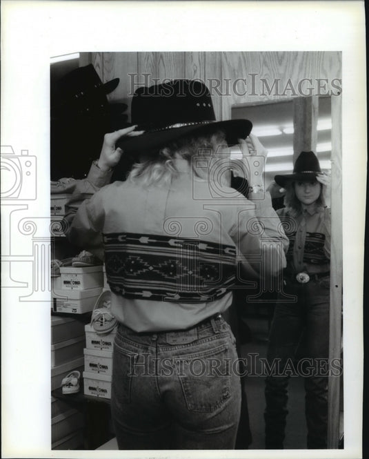 1993, Tracey Zsido tries on a hat at The Cowboy's Store. - mjp12358 - Historic Images