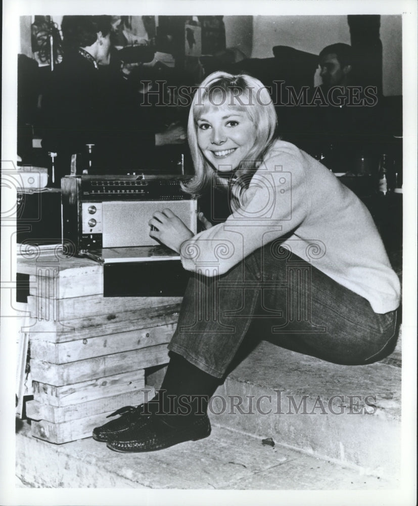 1968, English Actress Barbara Ferris smiles while tuning a radio - Historic Images