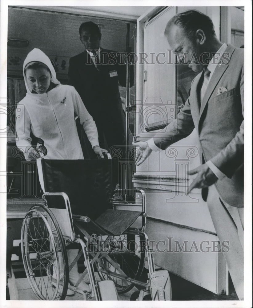 1965 Press Photo Wisconsin- Mimi Hines and Phil Ford demonstrate bus lift. - Historic Images