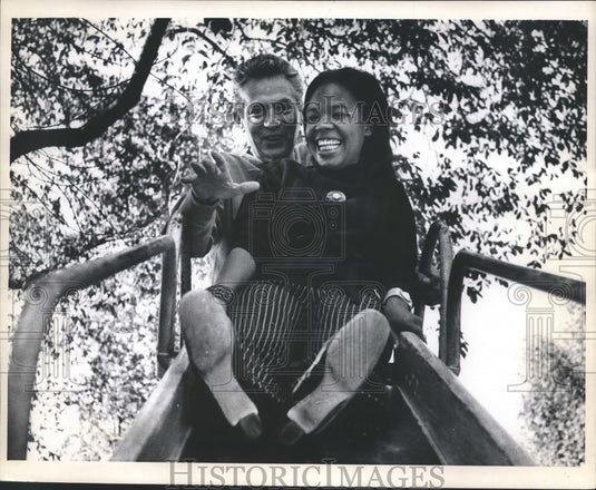 1968 Press Photo Peter Finch, actor, Eletha Barrett on slide in park, New York - Historic Images