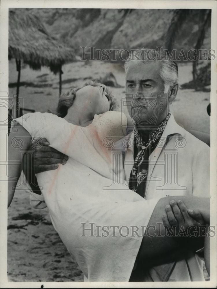 1969, Stewart Granger carrying unidentified lady on beach - mjp14463 - Historic Images
