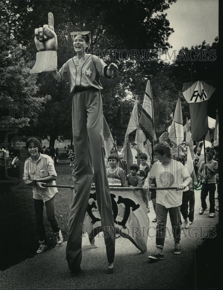 1987, Debbie Davis, a stilt walker with Friends Mime Theater leads - Historic Images