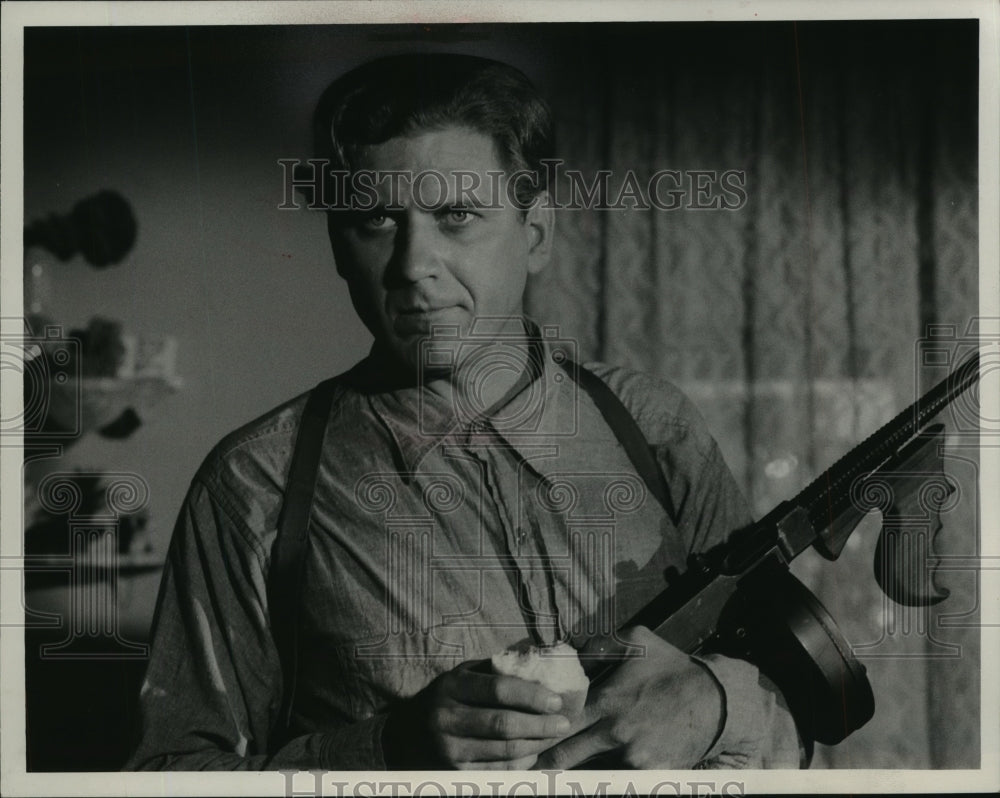 1975, Actor Robert Foxworth cleaning machine gun - mjp15455 - Historic Images