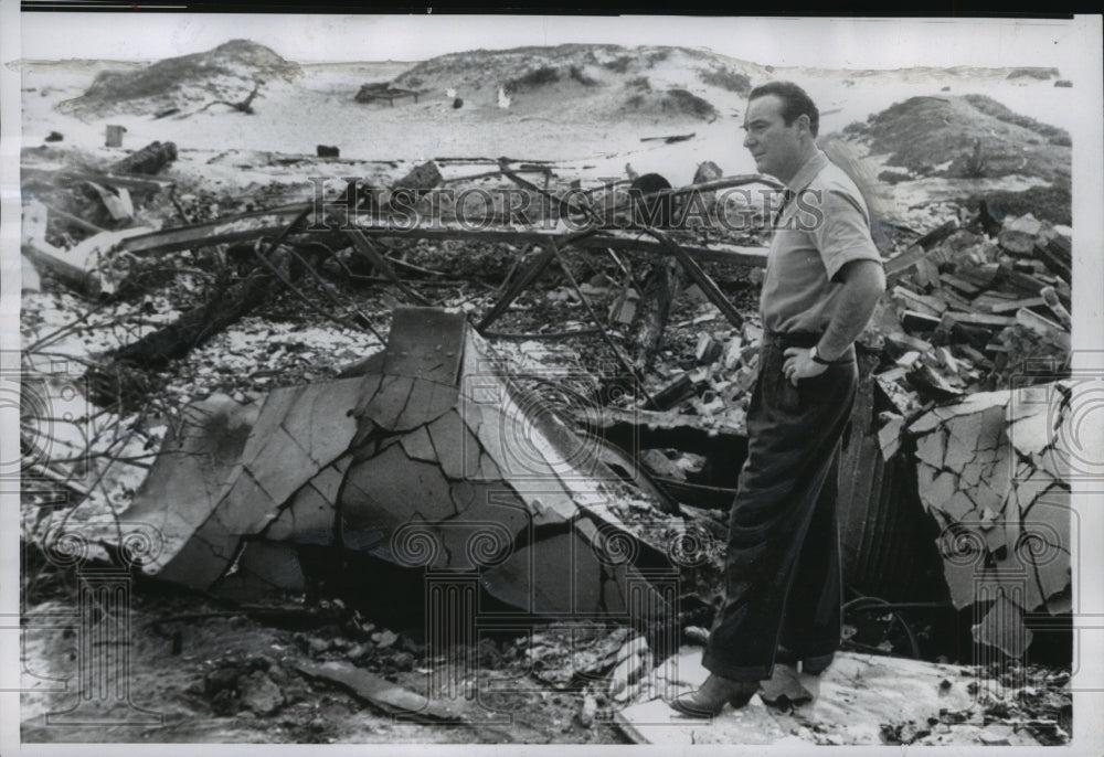 1956, Ralph Edwards, stands in ruins of damaged home, California. - Historic Images