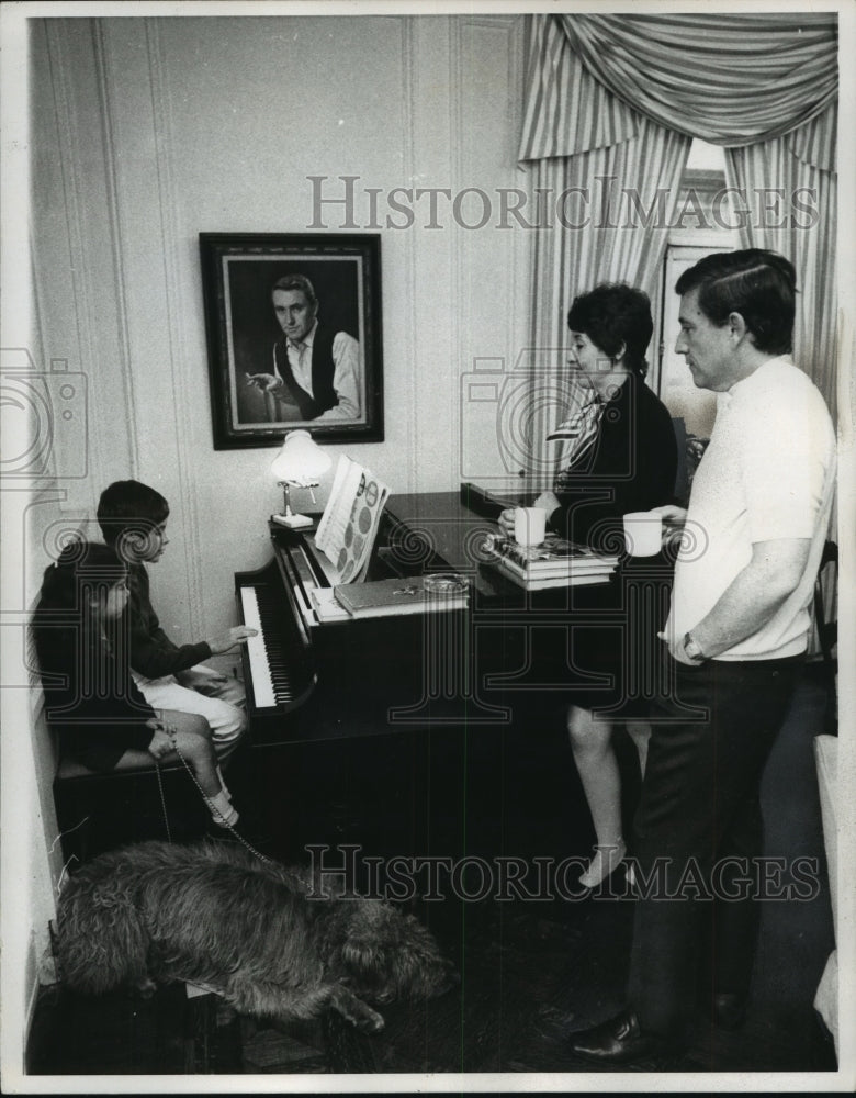 1969, Merv Griffin and wife Julann listen to their son play the piano - Historic Images