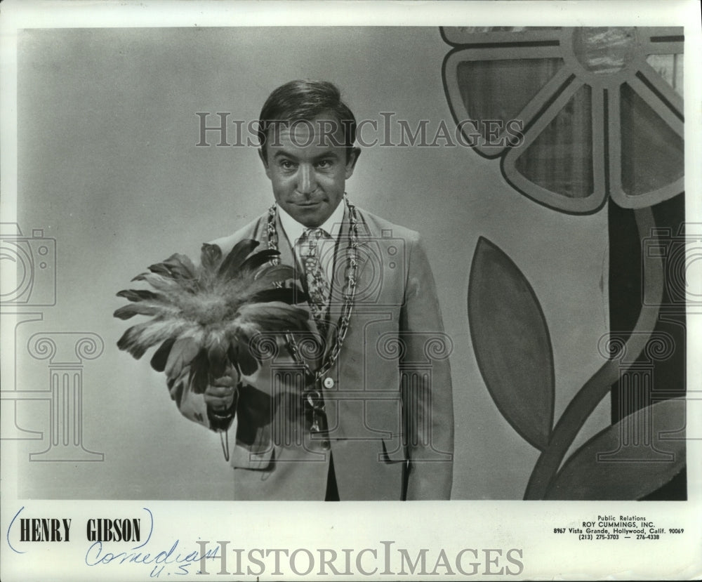 1969 Comedian Henry Gibson holds a feather bouquet. - Historic Images