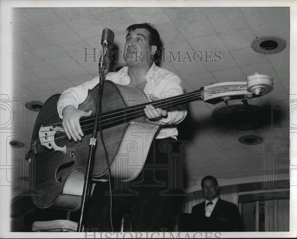 1962, Shecky Greene, impersonates a folk singer using a bass fiddle - Historic Images