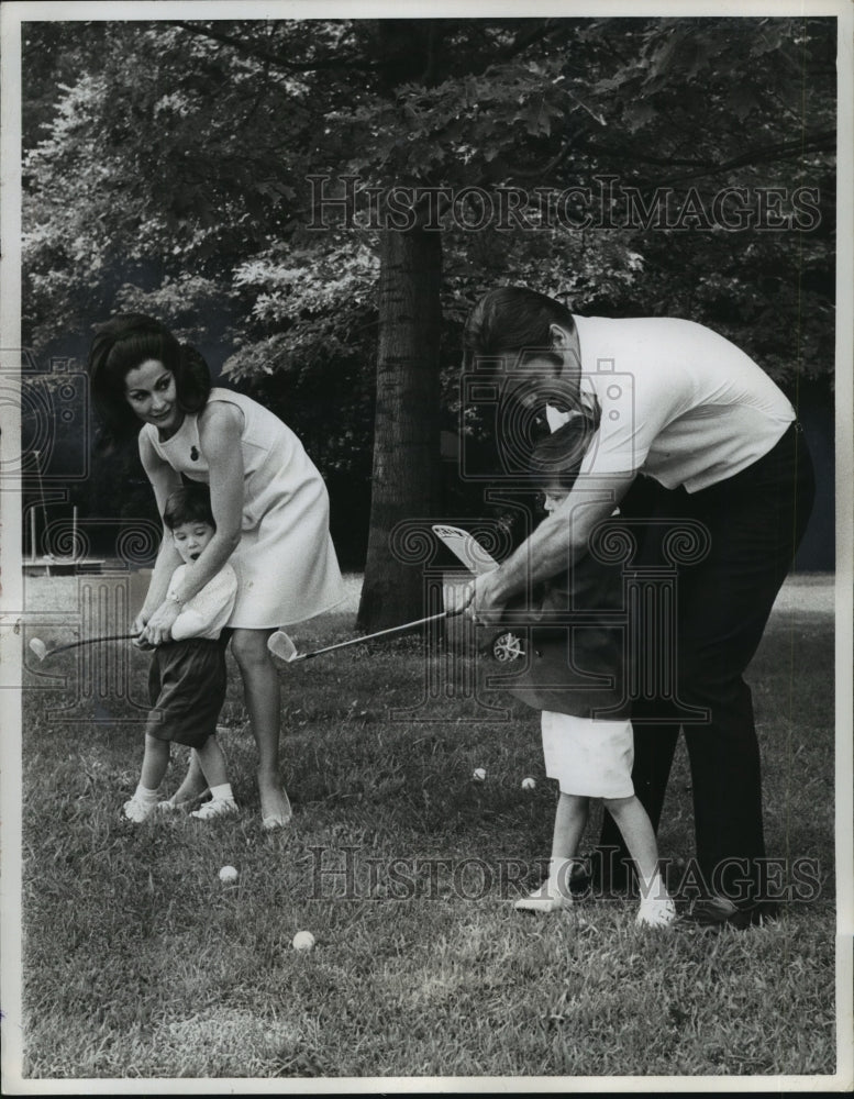 1968, Robert Goulet and wife give their sons a golfing lesson - Historic Images