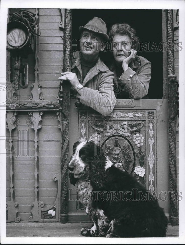 1967 Press Photo John Mills, wife look out door of home with dog - Historic Images