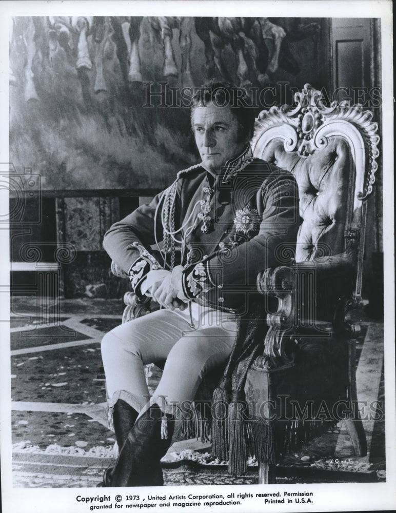 1973, Actor John Mills, in costume, sits on tufted chair, movie scene - Historic Images