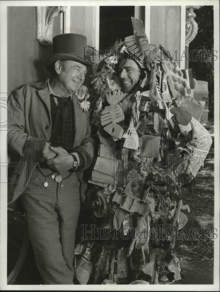 1972, Arthur Godfrey with unidentified person dressed in trash - Historic Images