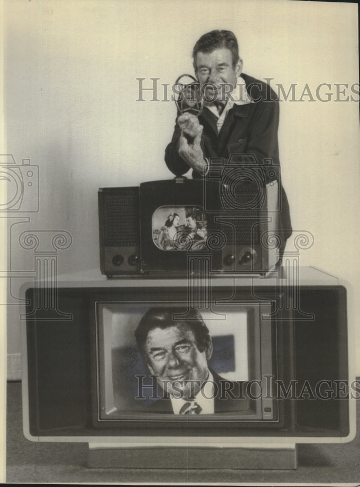 1977, Arthur Godfrey in Las Vegas with old microphone and televisions - Historic Images