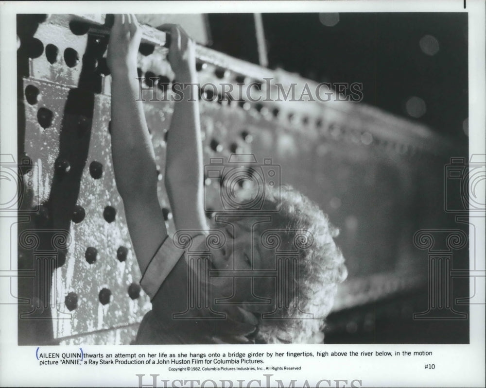 1982 Press Photo Actress Aileen Quinn hangs by her fingertips in &quot;Annie&quot; scene-Historic Images