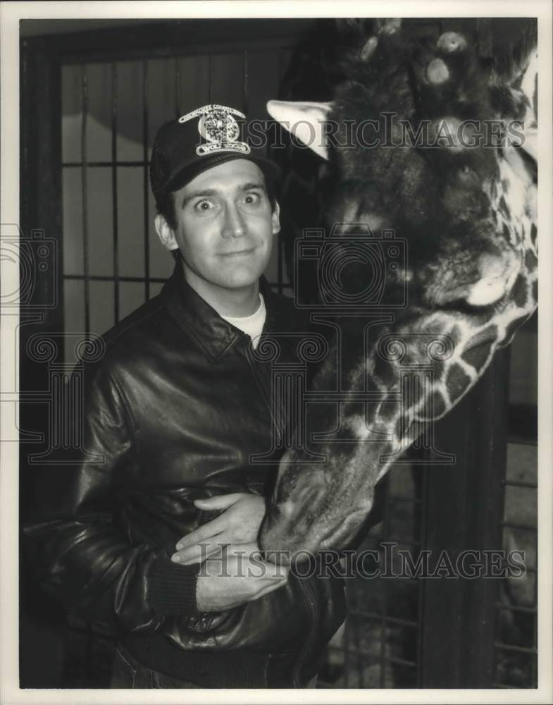 1985, Giraffe nibbles at filmmaker David Lee Miller's hand - Historic Images