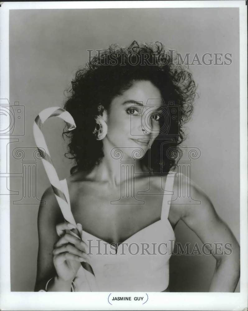 1988, Actress Jasmine Guy holding a big candy cane - mjp23310 - Historic Images